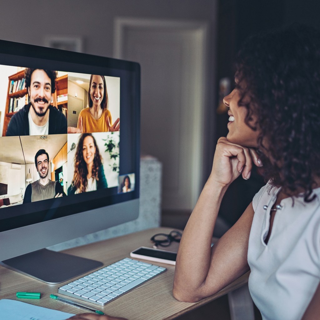 Woman having a video conference with 4 coworkers shown on her screen.